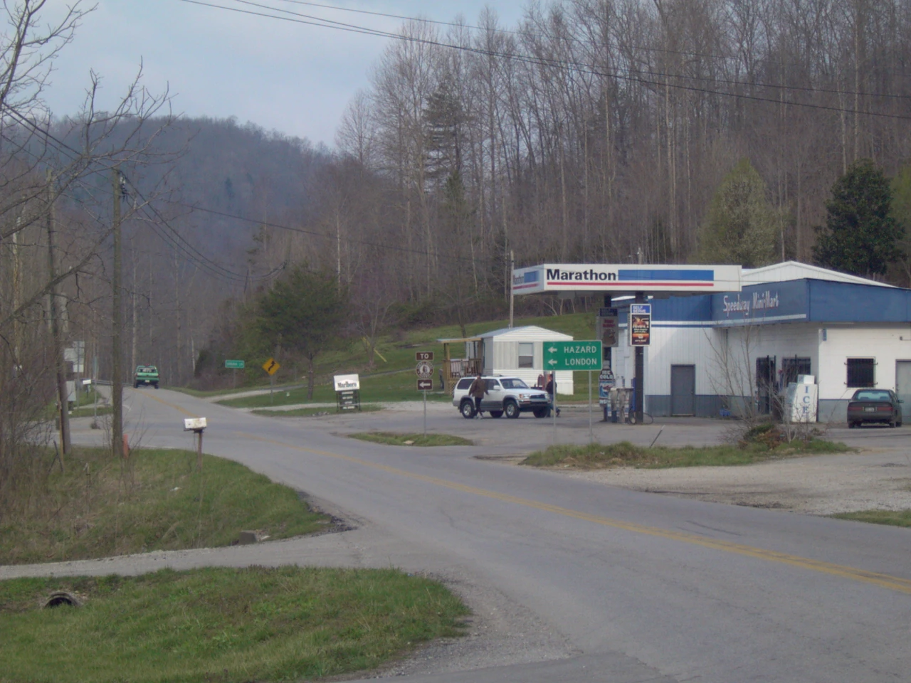 A Kentucky roadside store and gas station beneath wooded hills.